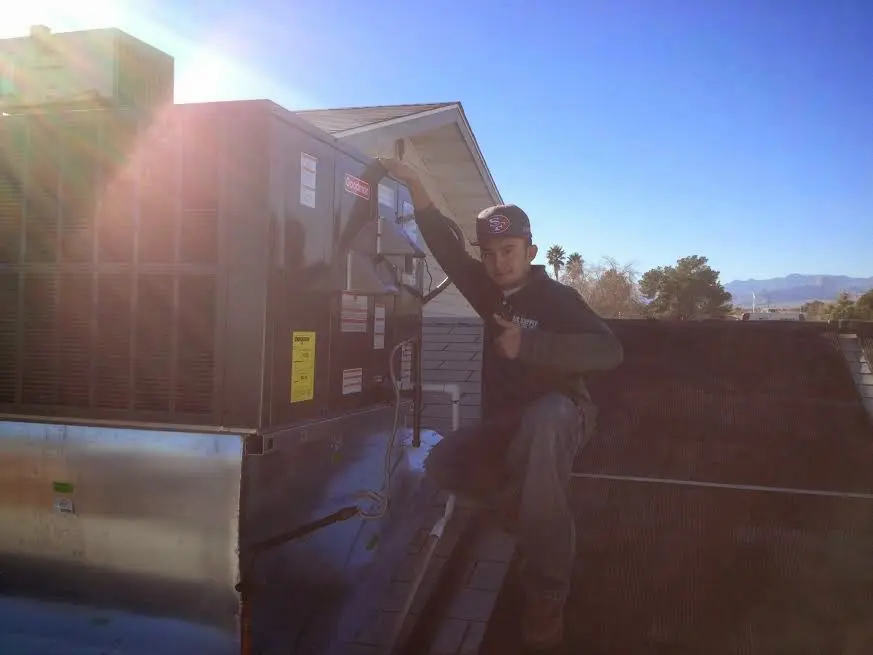 HVAC technician performing Boiler Repair on a rooftop unit in Midlothian